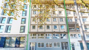 Un edificio de varios pisos con un diseño arquitectónico moderno, que cuenta con varias ventanas y balcones.