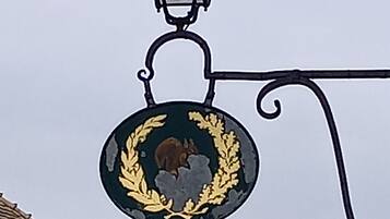A charming street lamp adorns the entrance of Auberge Commune, a historic establishment.