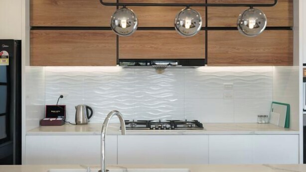 A modern kitchen with a white countertop, stainless steel sink, and a gas stove. - Snowy Peak Apartment (Lake Tekapo)
