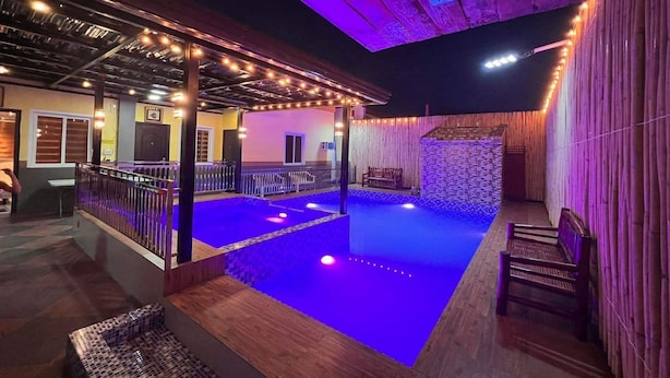 An indoor pool area with a wooden deck and a stone wall.