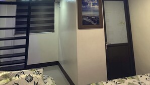 A room with a bunk bed, a framed picture on the wall, and a door with a frosted glass panel.