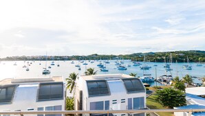 Un port de plaisance abritant de nombreux bateaux, offrant une vue sur l’eau et comprenant des bâtiments dotés de grandes fenêtres et de systèmes de climatisation.