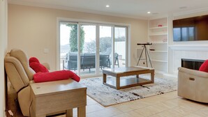 Een moderne woonkamer met een bank, een bijzettafeltje en een open haard.