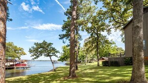 A lakeside property with a dock, trees, and a building.