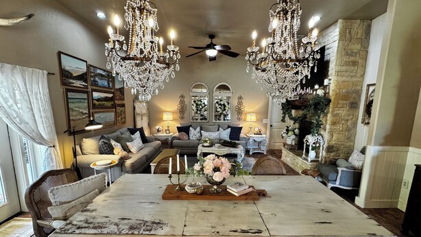 A spacious living room with a large white table, two grey sofas, and a chandelier. - Charming Farmhouse, Hot Tub, Pool, Outdoor Kitchen, Farm animals & Stocked Pond. (Diana)