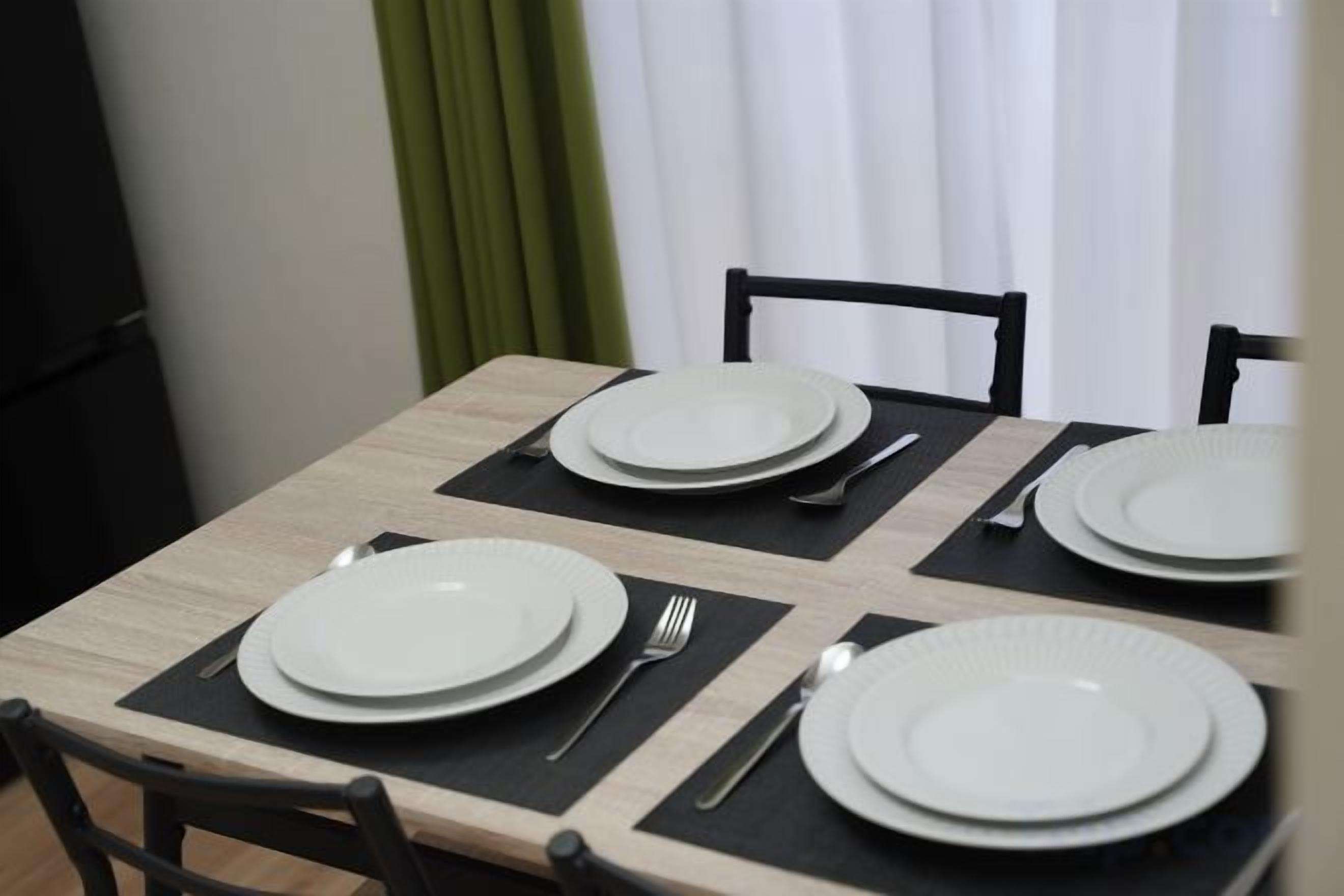 A dining table set with plates, cutlery, and a placemat.