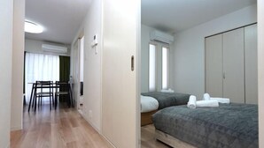 Une chambre d’hôtel comprenant un lit, une armoire, un bureau avec des chaises et une fenêtre avec des rideaux.