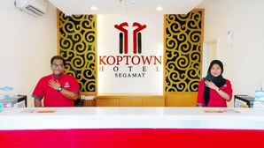 A reception desk with a logo for Koptown Hotel Segamat. - Syajie Koptown Hotel (Segamat)