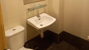 A small bathroom with a toilet, sink, and mirror. - Syajie Koptown Hotel (Segamat)