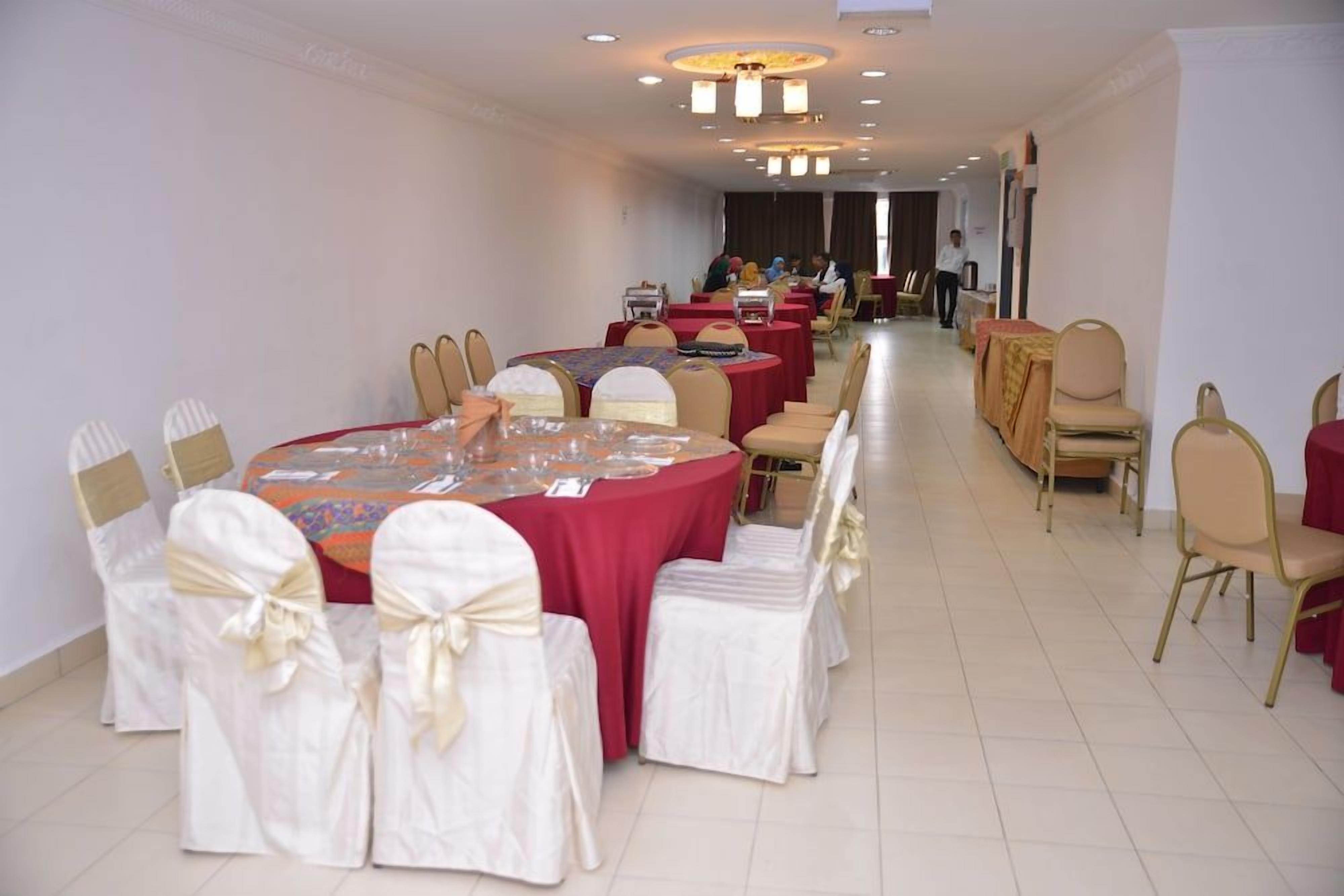 A banquet hall with round tables, chairs, and a long corridor.