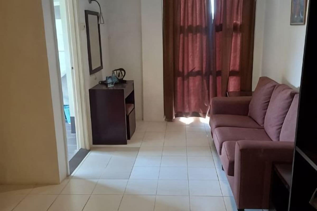 A living room with a sofa, a small table, and a TV.