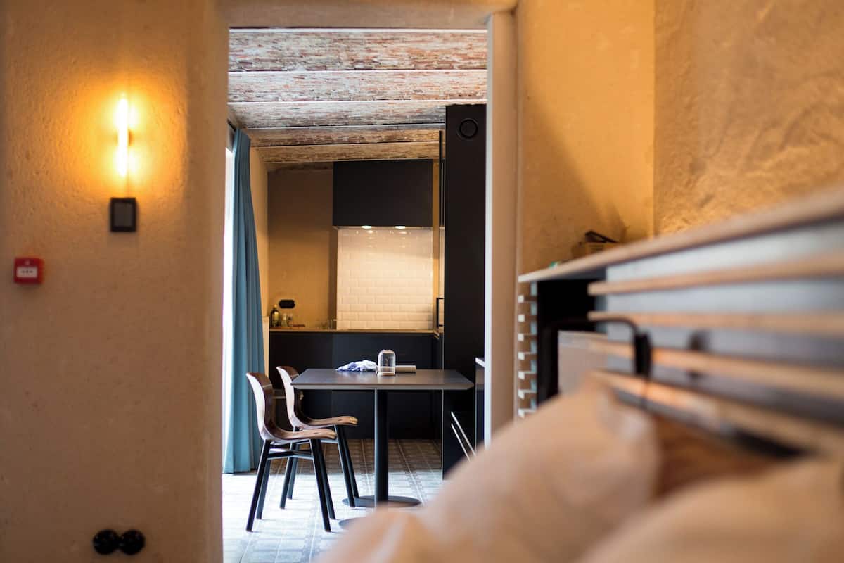 A narrow hallway leading to a dining area with a table and chairs.