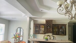 Una cocina con barra, armarios de madera y una araña.
