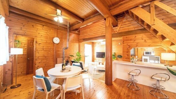 Un intérieur en bois comprenant un coin repas, une cuisine et un escalier.