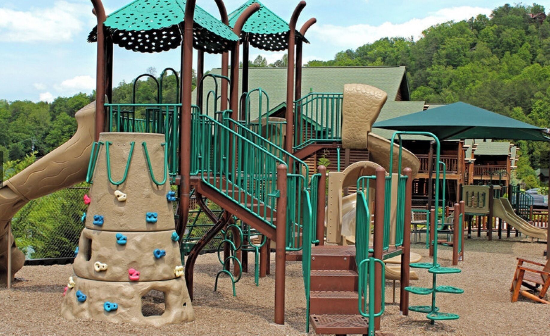 A playground with climbing structures, slides, and a covered area.