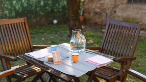 A wooden table with chairs, a glass pitcher, a cup, and a box of tissues. - ✨Relax at Lake Garda – Free Wi-Fi, Private Garden (Lombardia)