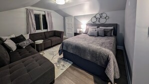 Una camera da letto moderna con un letto grande, una poltrona e una scrivania.