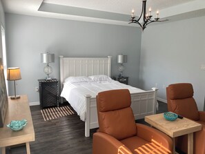Cozy retreat with a white bed, nightstands, and a seating area.