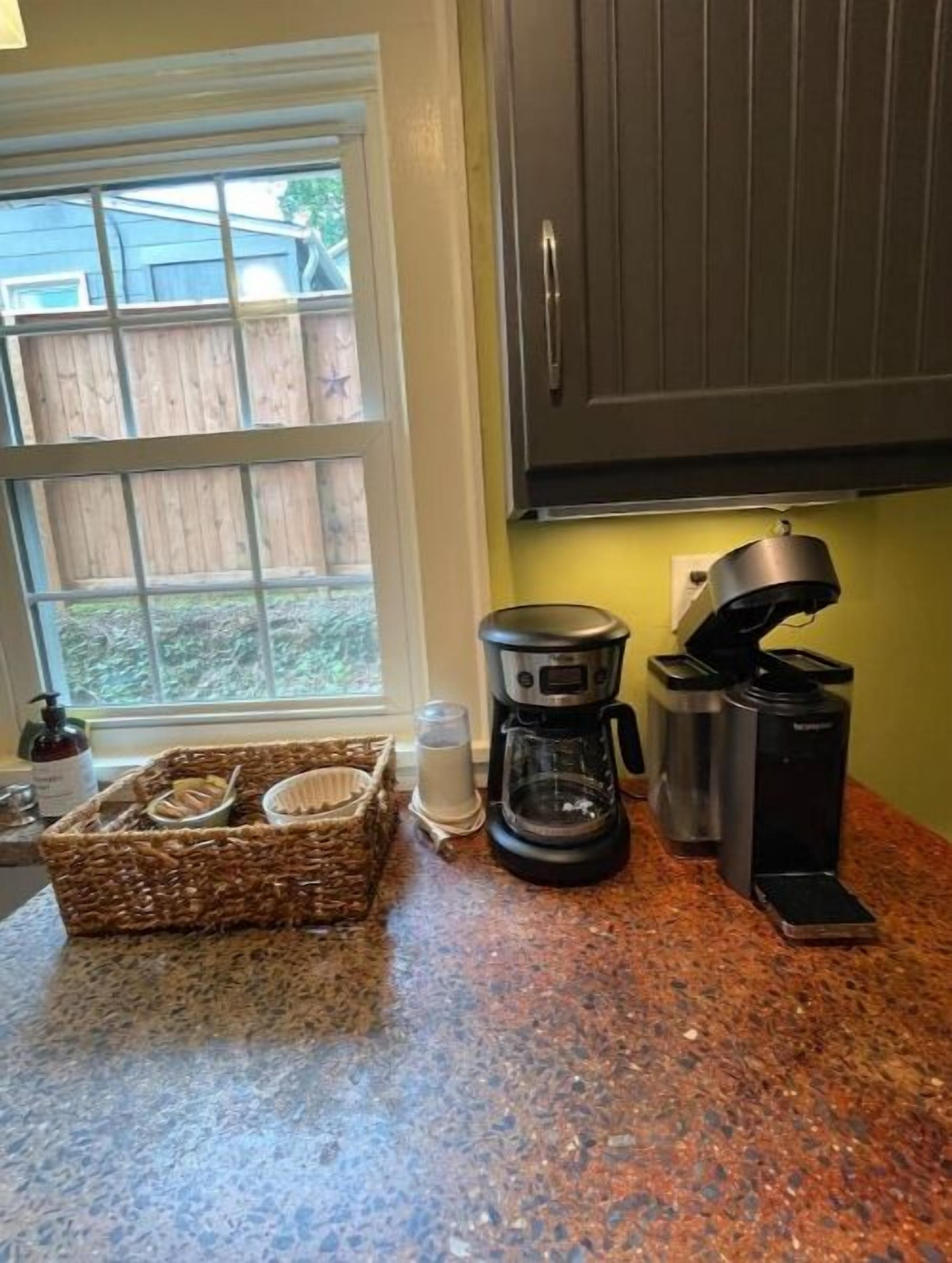 Une cuisine équipée d’un plan de travail en granit, d’une machine à café, d’un grille-pain et d’un panier de pain.