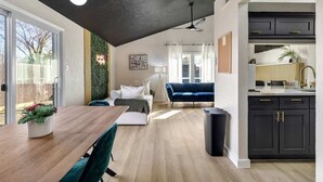 Una sala de estar moderna con comedor, cocina y vistas al exterior.