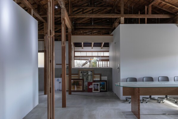 A conference room with a glass table, wooden beams, and framed artwork on the wall. - yutorie (Atami)