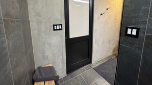 A modern hallway with a black door, a small wooden stool, and a mat at the entrance. - Rustic luxe Hideaway-near Beautiful American Fork Canyon! (Highland)