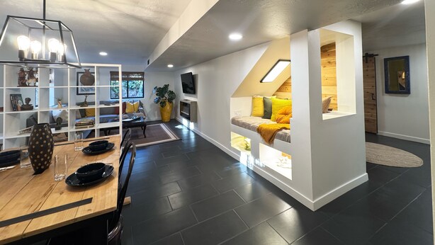 A modern living room with a dining area, a built-in seating area with a view, and a large plant. - Rustic luxe Hideaway-near Beautiful American Fork Canyon! (Highland)