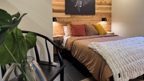 A bedroom with a wooden headboard, a bed with multiple pillows, a white throw blanket, and a wall-mounted picture of an elephant. - Rustic luxe Hideaway-near Beautiful American Fork Canyon! (Highland)
