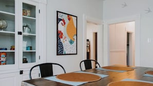 Un comedor con una mesa de madera, sillas y un cuadro colgado en la pared.