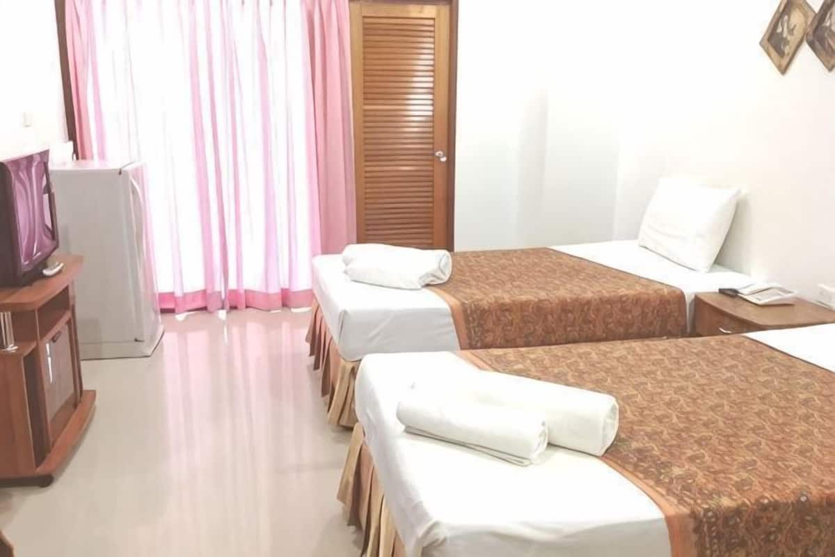 A hotel room with two beds, a desk, a chair, a TV, and a wardrobe.