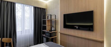 Una habitación de hotel moderna con una cama grande, un televisor montado en la pared, un diseño de paneles de madera y una ventana con cortinas.