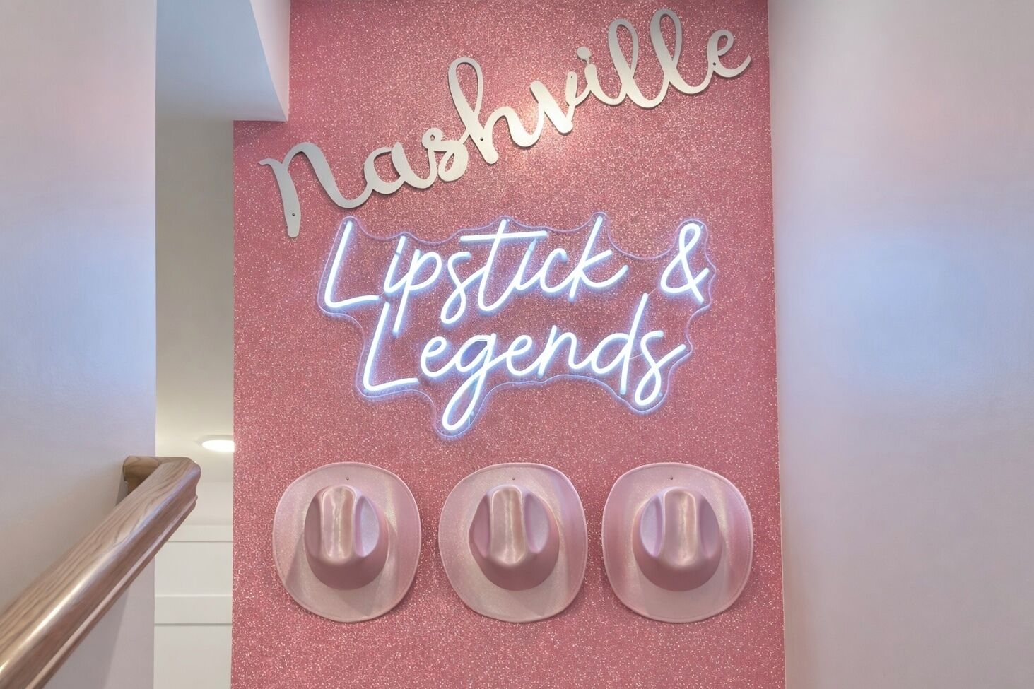 A neon sign with "Nashville Lipstick & Legends" on a pink glittery wall.