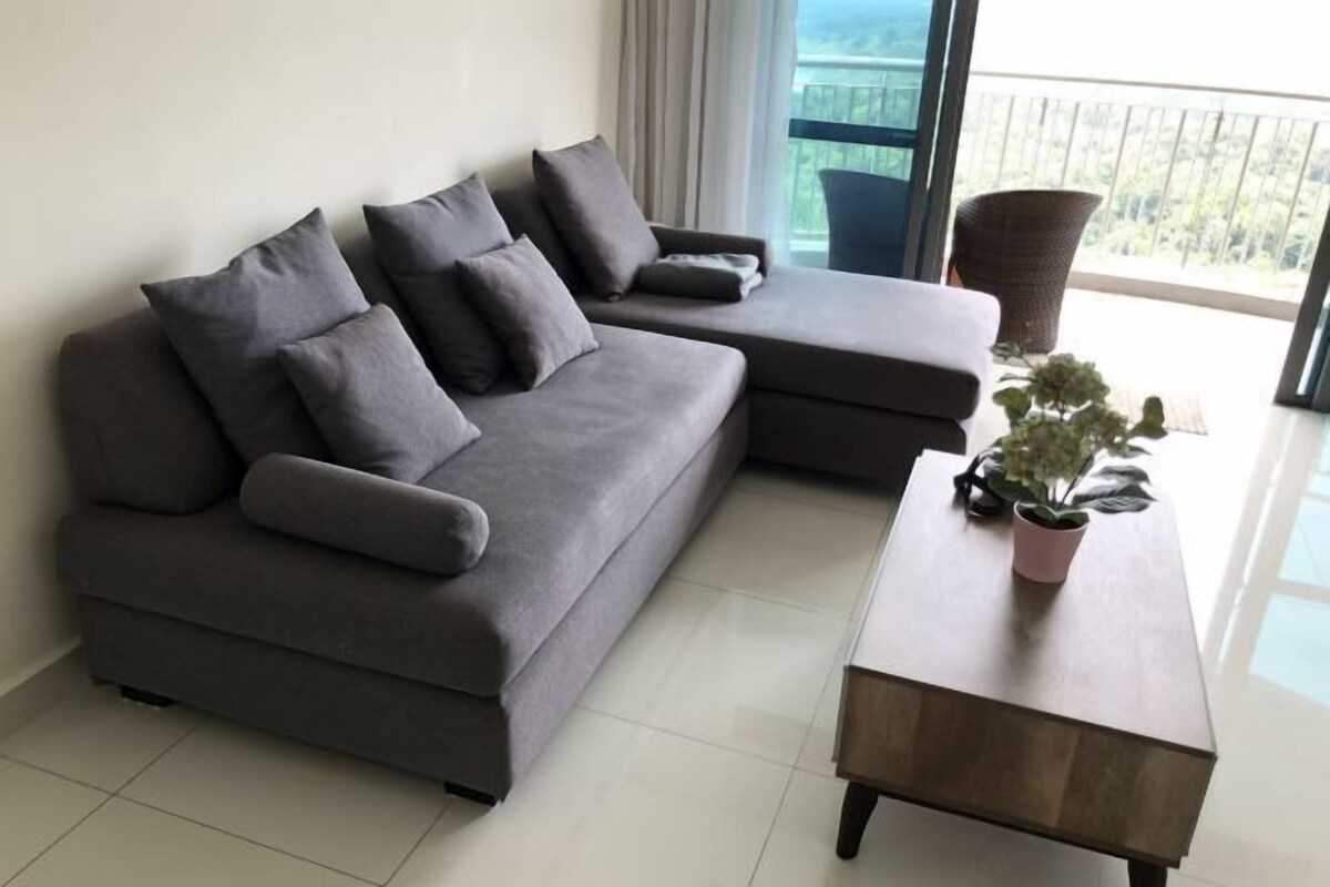 A modern living room with a grey sectional sofa, a wooden coffee table, and a potted plant.