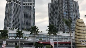 A high-rise hotel with multiple floors, palm trees, and a sign for "Puteh Harbour Resort". - Teega Residence Waterfront Living (Iskandar Puteri)