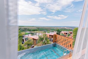 A pool area with a view of a building complex and surrounding landscape. - Sky Hill Villa Surattthani (Surat Thani)