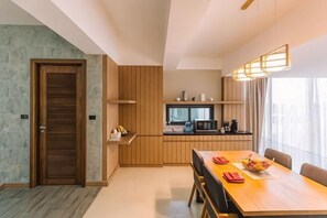 A modern kitchen with wooden cabinets, a dining table with chairs, and a large window.