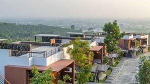 Un barrio residencial con casas modernas, vistas despejadas del paisaje circundante y un horizonte urbano distante.