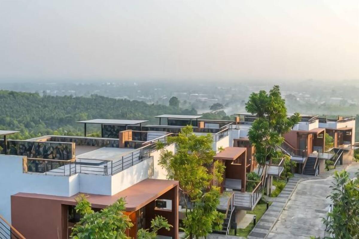 A residential area with modern houses, a clear view of the surrounding landscape, and a distant cityscape.
