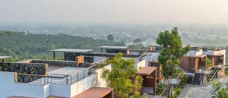 A residential area with modern houses, a clear view of the surrounding landscape, and a distant cityscape.