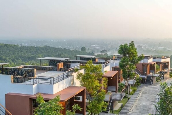 A residential area with modern houses, a clear view of the surrounding landscape, and a distant cityscape. - Sky Hill Villa Surattthani (Surat Thani)
