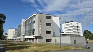 Un bâtiment moderne arborant fièrement l’inscription « BAUHAUS », caractérisé par un mélange de façades en verre et en béton, et doté d’un toit plat.