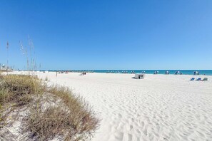A wide sandy beach with clear blue sky, some beach umbrellas, and a few lounge chairs. - Summer House 905A | Gulf Front | Resort Amenities | My Beach Getaways (Orange Beach)