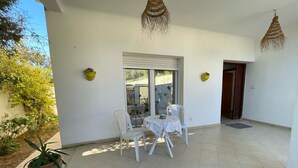 A covered patio area with a table and chairs, a potted plant, and hanging lights. - Cozy 2-Bedroom one level house in La Marsa – Perfect Location & Comfort! (La Marsa)