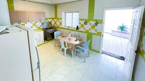 A compact kitchen with a dining area, featuring a stove, refrigerator, and a window with a view. - Cozy 2-Bedroom one level house in La Marsa – Perfect Location & Comfort! (La Marsa)
