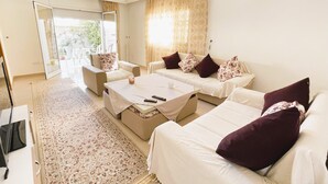 A spacious living room with two sofas, a coffee table, and a patterned rug. - Cozy 2-Bedroom one level house in La Marsa – Perfect Location & Comfort! (La Marsa)