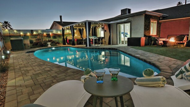 A backyard with a swimming pool, a covered patio area, and outdoor seating. - Lunar: Old Town Luxury• Heated Pool• 2 Kings• Gameroom• Hottub• Karaoke• Privacy (Scottsdale)