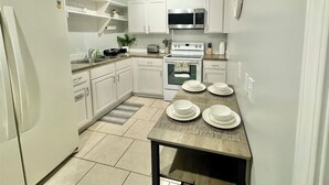 A compact kitchen with white cabinets, a microwave, a toaster, and a sink.