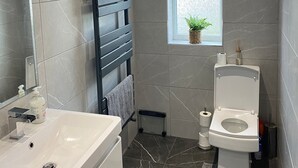 Een haardroger, handdoeken, zeep, toiletpapier