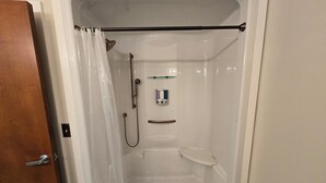 A white walk-in shower with a handheld showerhead, a handheld showerhead, a glass shower caddy, and a handheld showerhead. - Spacious House Ideal for Sports Teams, Across from Spooky Nook in Manheim, PA (Manheim)