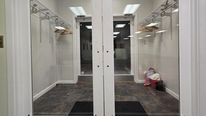 A hallway with a mirrored wall, a metal rack, and a red trash bin. - Spacious House Ideal for Sports Teams, Across from Spooky Nook in Manheim, PA (Manheim)